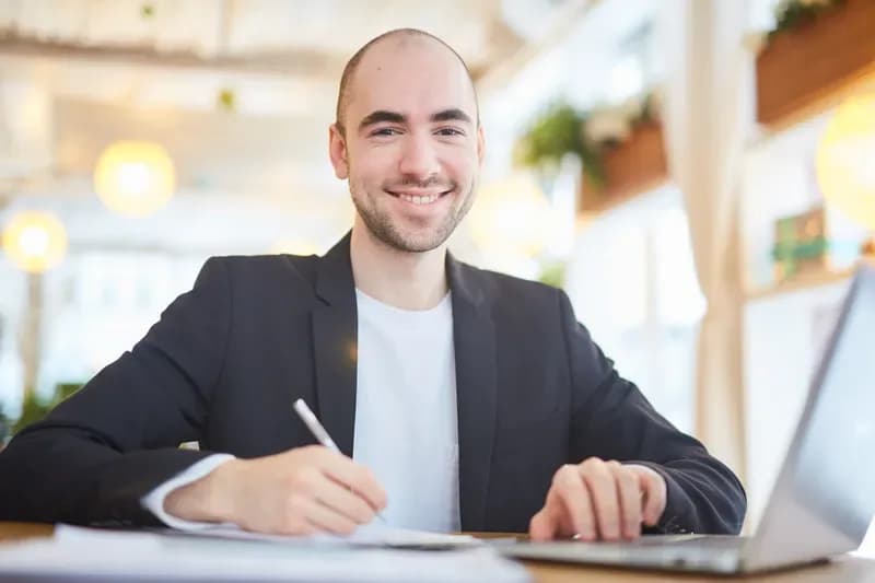 Gutachter am Schreibtisch mit Unterlagen und Laptop