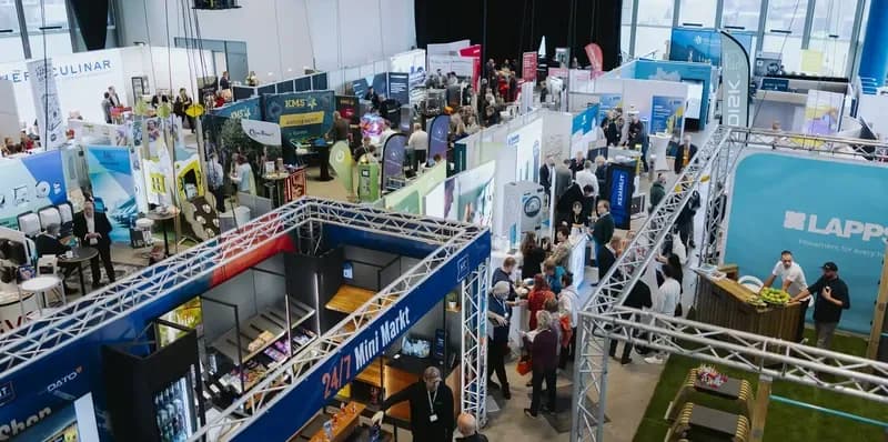 Blick von oben in die Messehalle des Norddeutschen Campingtags mit Ausstellungsständen und Besuchern