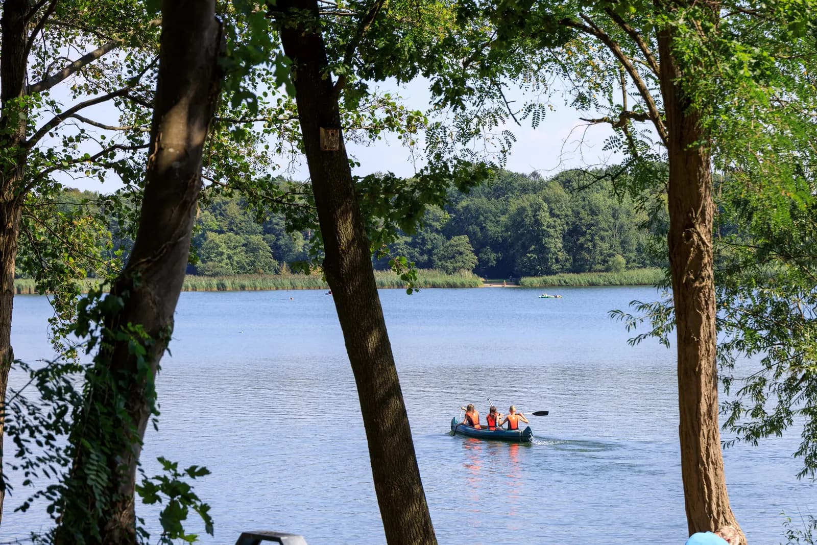 Kanu mit drei Personen auf einem stillen See